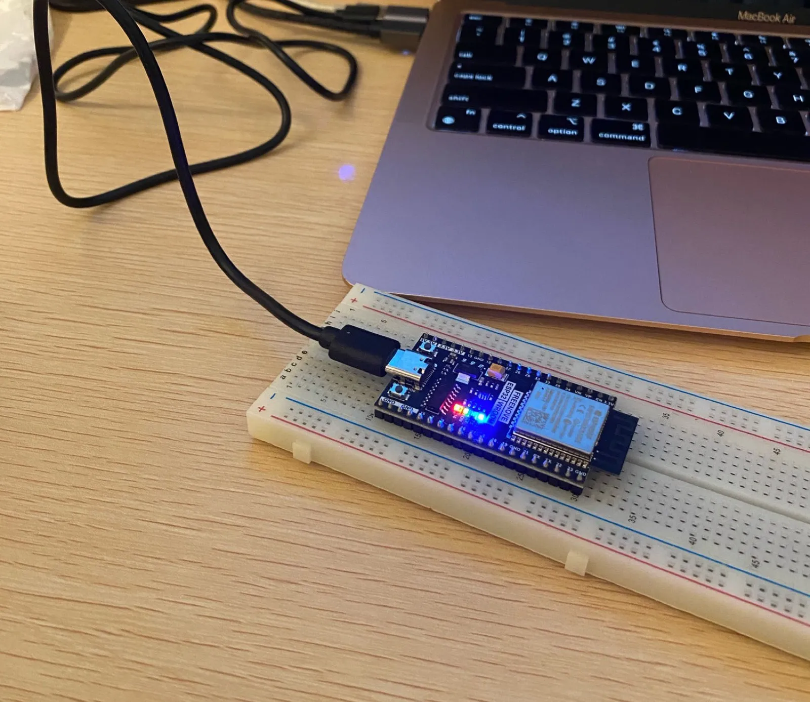 ブレッドボードに挿した ESP32。青い LED が点灯している